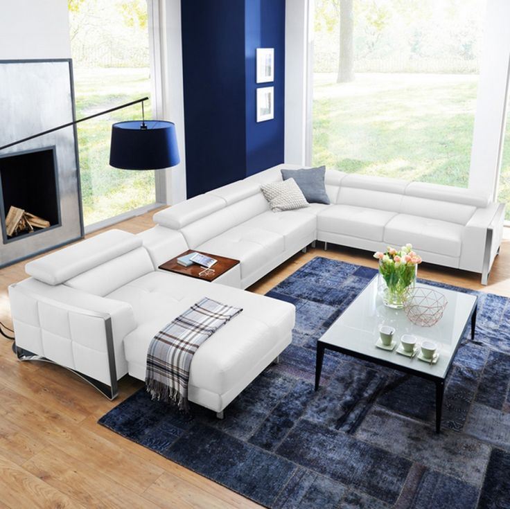Белый диван в интерьере: кожаный белый диван в гостиной с синим ковром и стенами