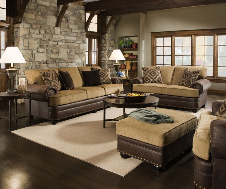 Бежевый диван в интерьере: кожаные двухцветные в в гостиной из тёмного дерева с кирпичной кладкой стены