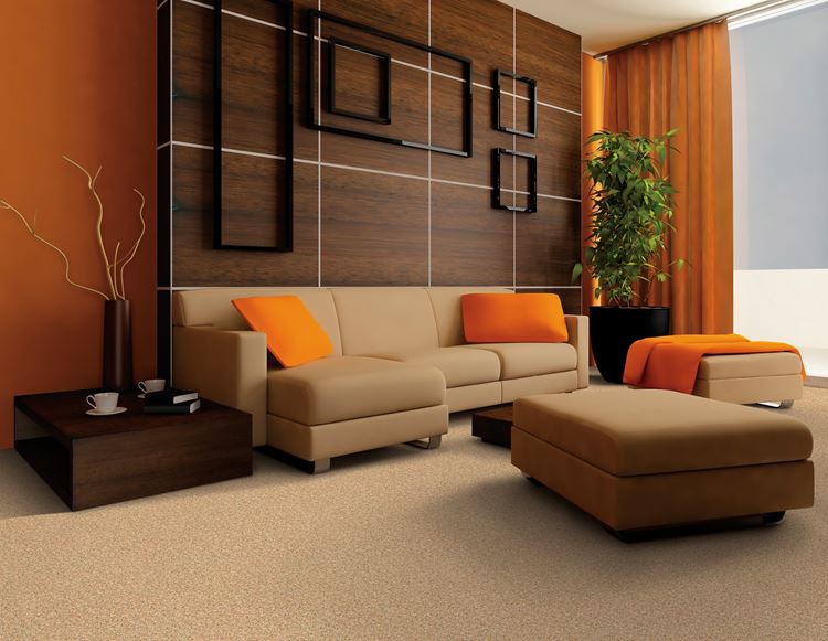 Бежевый диван в интерьере: деревянная стена, оранжевые аксессуары и бежевый ковер
