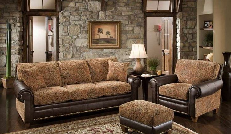 Бежевый диван в интерьере: гостиная с кирпичными стенами и кожаным диваном и креслами