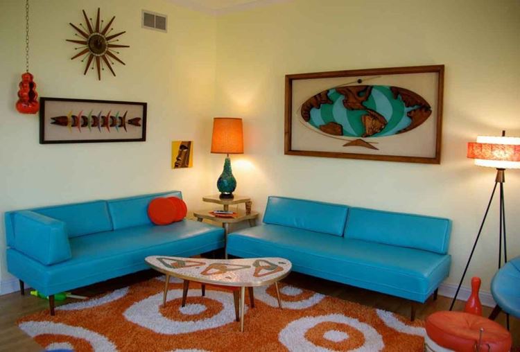 Бирюзовый диван в интерьере: два ярких кожаных сине-бирюзовых оттенка с оранжевым ковром и жёлтыми стенами