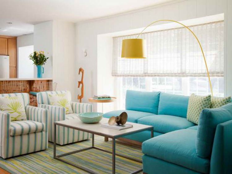 Бирюзовый диван в интерьере: угловой диван в комнате с белыми стенами и двумя креслами в бело-зеленую полоску
