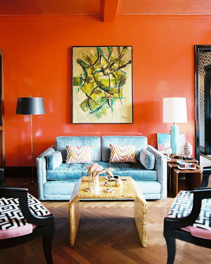 Голубой диван в интерьере: двухместный диван в гостиной с яркими оранжевыми стенами