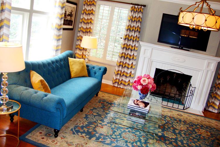 Голубой диван в интерьере: диван в стиле барокко в комнате с камином, узорчатым ковром и полосатыми шторами