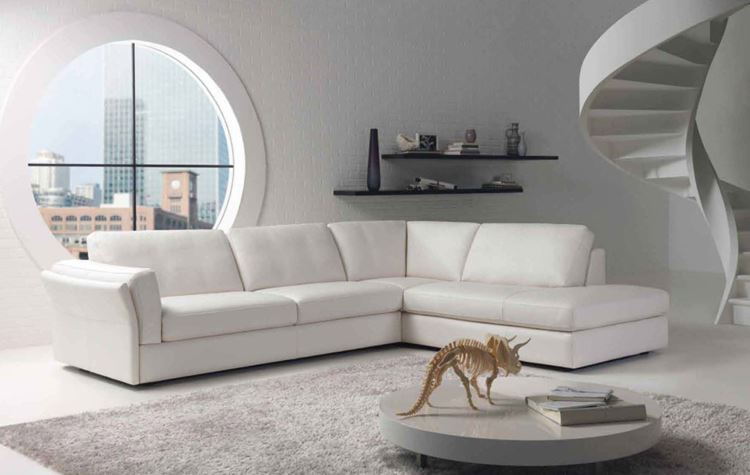 Белый диван в интерьере: большой кожаный угловой в светлой гостиной с ковром и круглым окном
