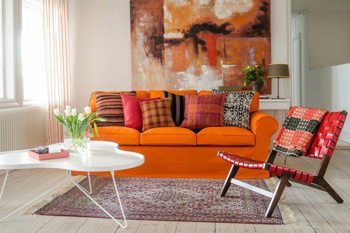 Оранжевый диван в интерьере: мягкий оранжевый трёхместный диван с разноцветными подушками