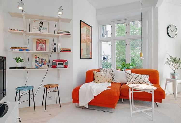 Оранжевый диван в интерьере: белая комната с ярким мягким диваном