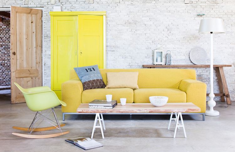 Жёлтый диван в интерьере: гостиная в стиле лофт с кирпичной стеной и мягким жёлтым бархатным диваном