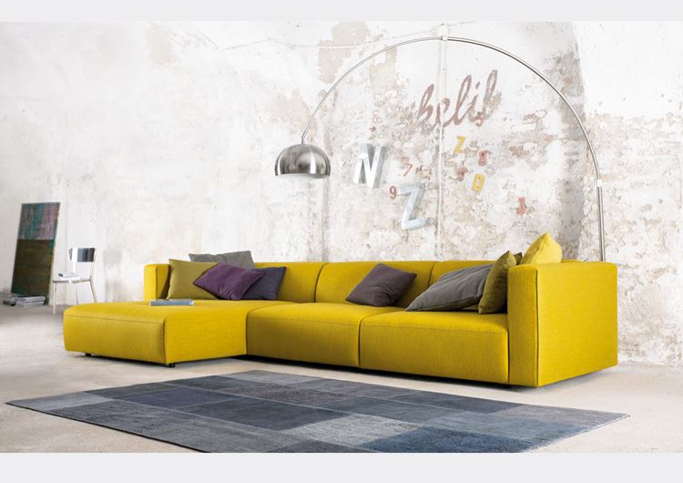 Жёлтый диван в интерьере: Квартира-студия с угловым диваном с фиолетовыми и серыми подушками