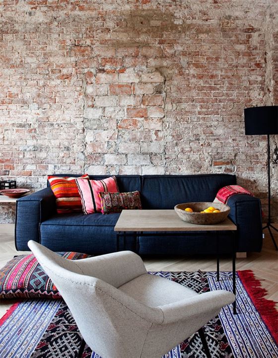 Джинсовый диван - интерьер в стиле лофт с кирпичной стеной и восточными коврами и подушками